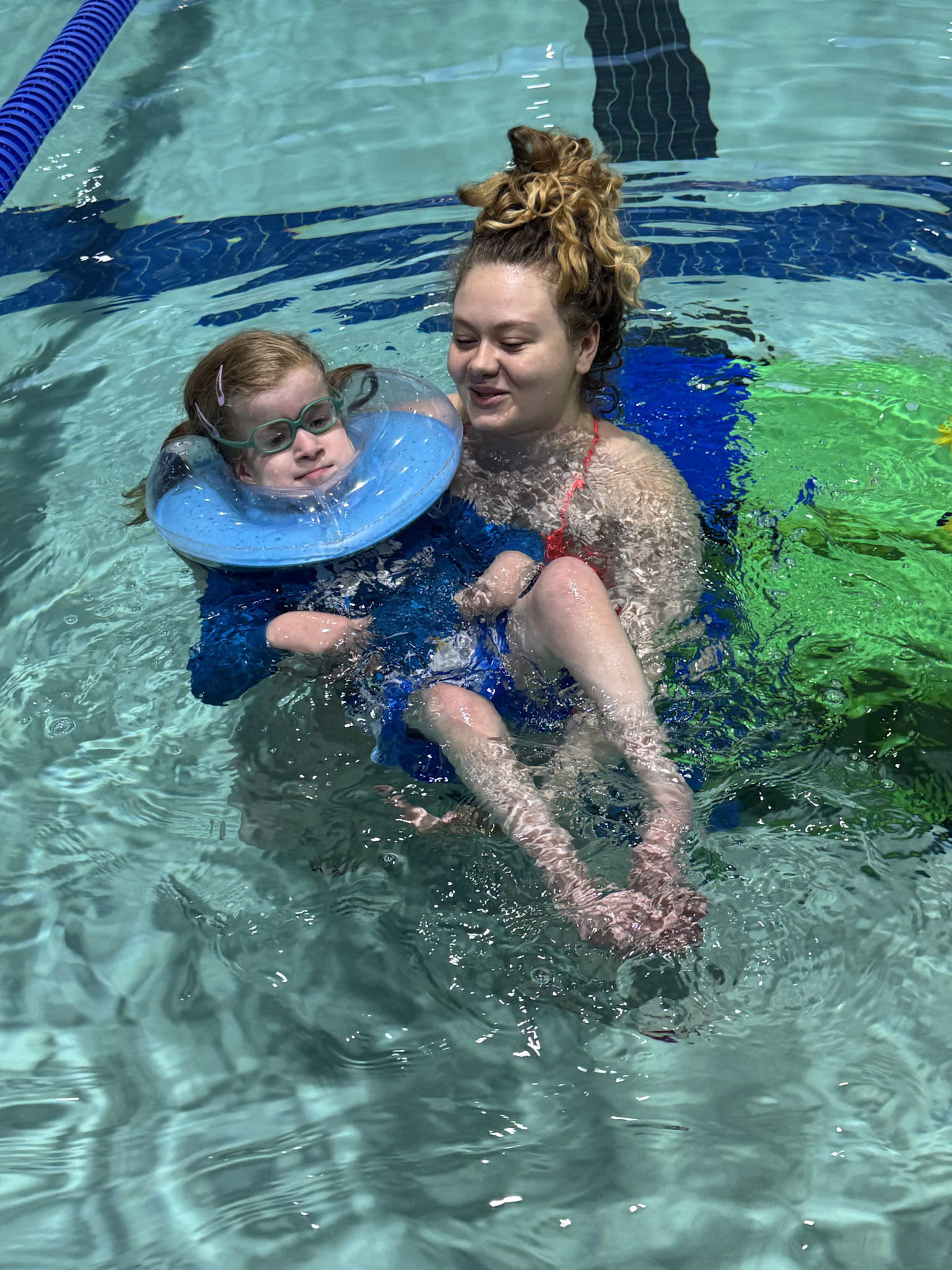 Child participating in aquatic physical therapy exercises in a pool