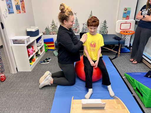 Pediatric physical therapy session taking place on land
